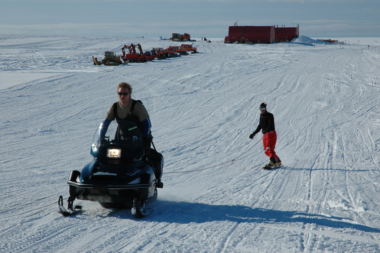 Ski-jouring, vehicles and garage in background
