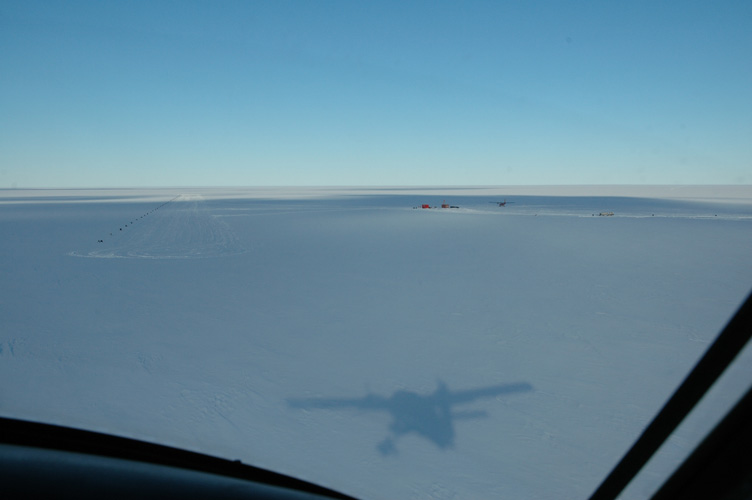 The plane rushes towards its shadow at the skiway