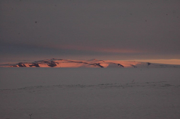 The dipping sun casts a red glow on White Island